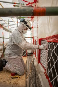 arbeider maakt hermetische zone voor asbestverwijdering