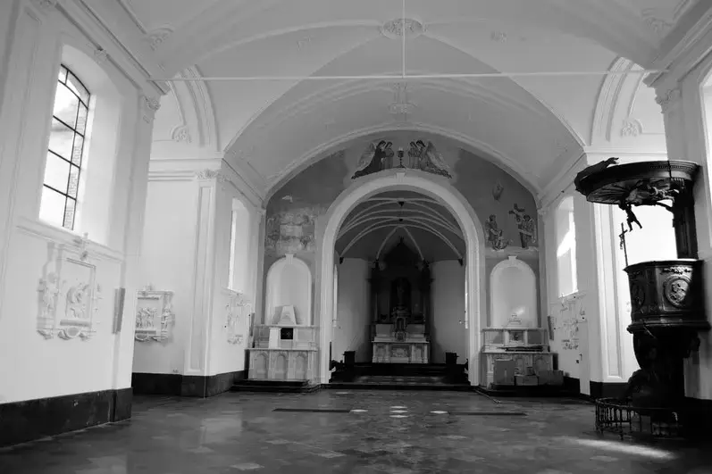 Historisch kerkinterieur met gerestaureerd stucwerk, gewelfplafonds, muurornamenten en centraal altaar, als onderdeel van een gespecialiseerd restauratieproject.
