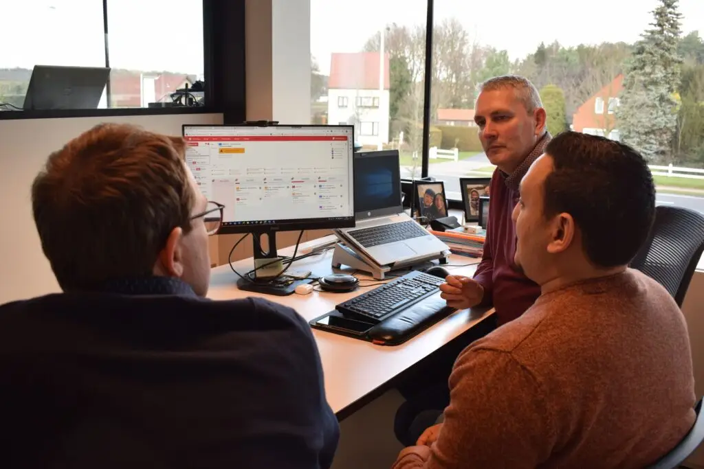 Overleg in kantooromgeving bij Renotec, waarbij een intuïtieve digitale applicatie op meerdere schermen wordt besproken en getest als maatwerk IT‑oplossing voor interne divisies.