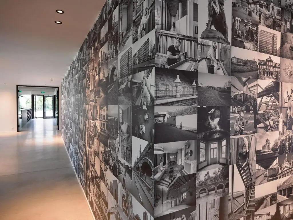 Gang in het hoofdkantoor van Renotec in Geel met fotowand van gerealiseerde renovatie- en restauratieprojecten.