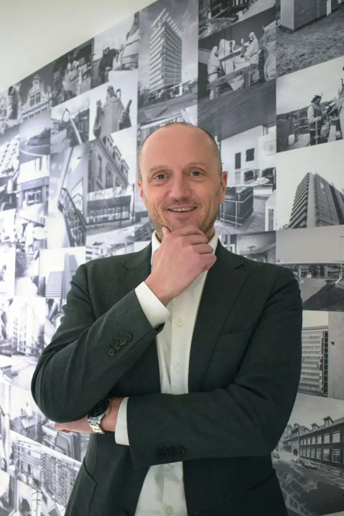 Portret van Roeland Fraussen, CEO van Renotec, gefotografeerd voor een collage van bouw‑ en renovatieprojecten die het vakmanschap en de expertise van Renotec in renovatie, restauratie en herbestemming weerspiegelen.