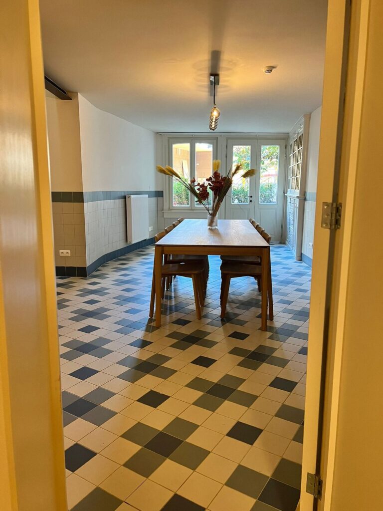 interieur van een co‑livingproject met gemeenschappelijke leef- en eetruimte, gerealiseerd door Renotec – divisie Restauratie en Herbestemmingen – waarbij een bestaand gebouw zorgvuldig werd getransformeerd tot hedendaags en duurzaam woonconcept.